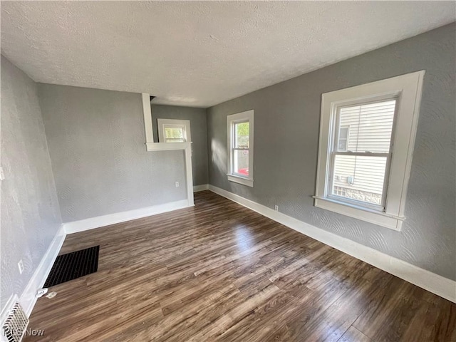 1072 Pitkin Ave, Akron, OH 44310 - empty room with dark wood-type flooring and a textured ceiling