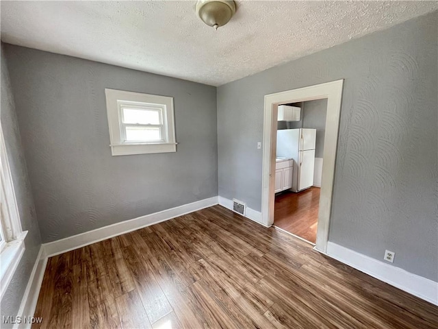 1072 Pitkin Ave, Akron, OH 44310 - unfurnished room with dark wood-style floors and a textured ceiling