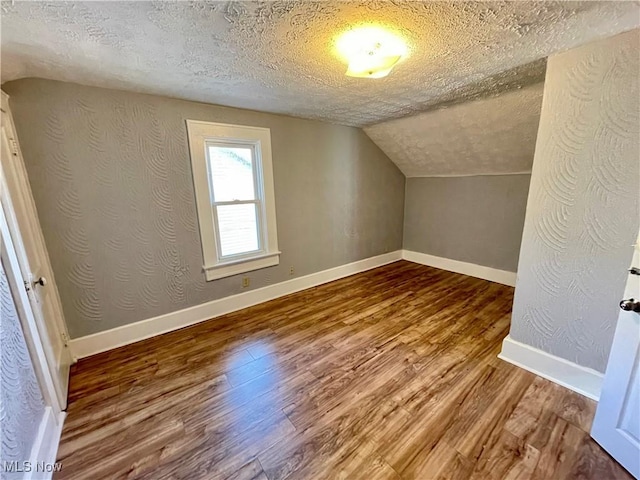 1072 Pitkin Ave, Akron, OH 44310 - additional living space with a textured ceiling, wood finished floors, and vaulted ceiling