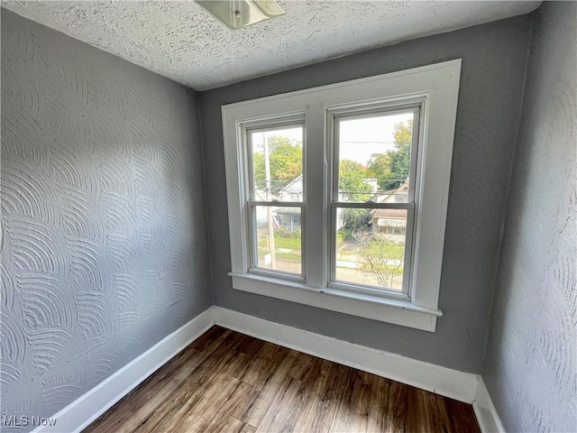 1072 Pitkin Ave, Akron, OH 44310 - empty room with dark wood-style floors and a textured ceiling