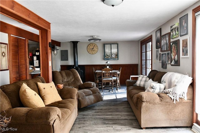 1511 Lake Front Dr, Salem, OH 44460 - living area featuring wood finished floors, a wainscoted wall, electric panel, and a wood stove
