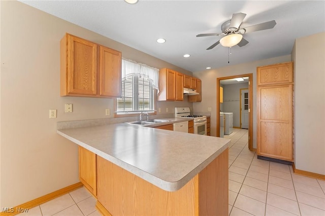7900 Walnut St Unit 10, Boardman, OH 44512 - kitchen with white range with gas stovetop, light countertops, a peninsula, light tile patterned floors, and washing machine and clothes dryer