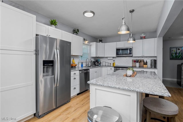 1921 Adrian Cir, Sandusky, OH 44870 - kitchen featuring stainless steel appliances, light wood-type flooring, decorative backsplash, and a kitchen bar