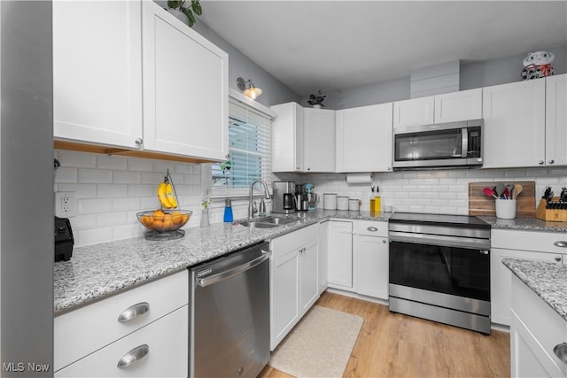 1921 Adrian Cir, Sandusky, OH 44870 - kitchen with stainless steel appliances, white cabinetry, and light wood-type flooring