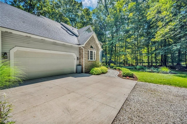 949 S Medina Line Rd, Wadsworth, OH 44281 - view of home's exterior with concrete driveway, an attached garage, brick siding, a shingled roof, and a yard