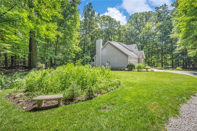 949 S Medina Line Rd, Wadsworth, OH 44281 - view of side of home featuring an attached garage, a yard, a chimney, and driveway