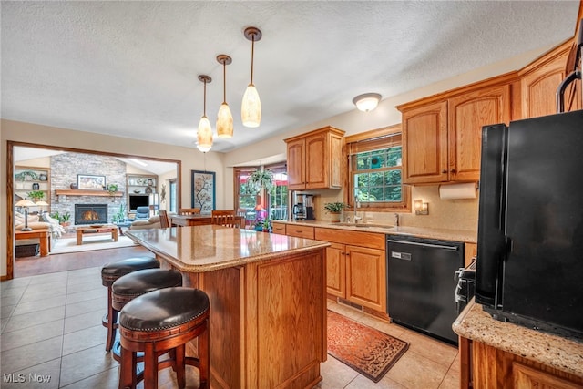 949 S Medina Line Rd, Wadsworth, OH 44281 - kitchen featuring black appliances, a center island, a breakfast bar area, light tile patterned flooring, and a textured ceiling