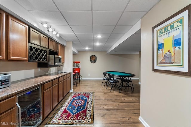 4276 Brownstone Ln, Medina, OH 44256 - kitchen with wine cooler, wood finished floors, a drop ceiling, brown cabinetry, and stainless steel microwave