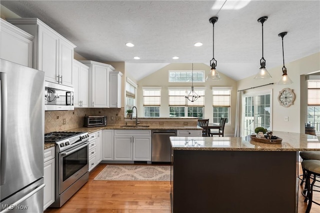 4276 Brownstone Ln, Medina, OH 44256 - kitchen featuring appliances with stainless steel finishes, light wood-style flooring, a breakfast bar area, white cabinets, and backsplash