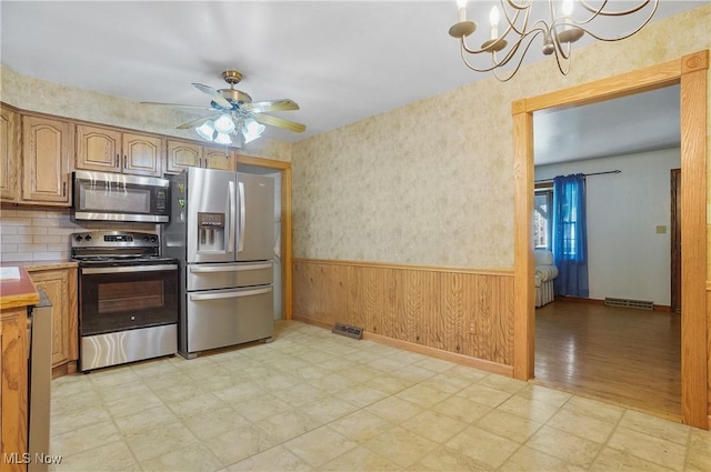 662 Beech Ave, Youngstown, OH 44512 - kitchen featuring stainless steel appliances, light floors, a wainscoted wall, ceiling fan, and a chandelier
