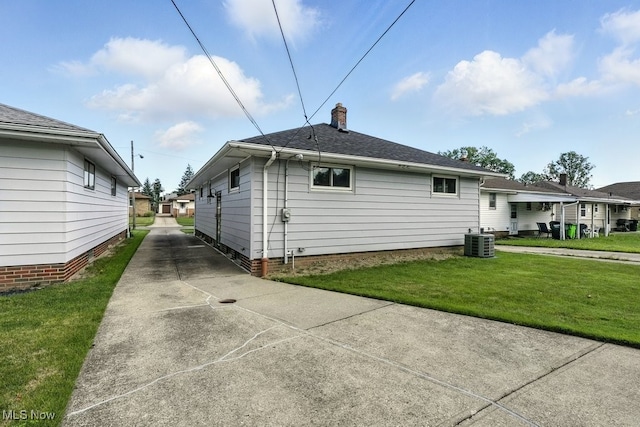 13806 Carpenter Rd, Garfield Heights, OH 44125 - view of side of home featuring a yard, a chimney, and concrete driveway