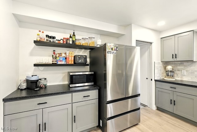 13806 Carpenter Rd, Garfield Heights, OH 44125 - kitchen with stainless steel appliances, open shelves, dark countertops, and decorative backsplash