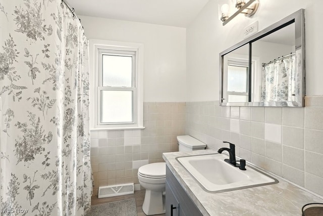 13806 Carpenter Rd, Garfield Heights, OH 44125 - full bathroom featuring tile walls, vanity, a shower with curtain, and a wainscoted wall