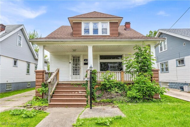 3670 E 138th St, Cleveland, OH 44120 - bungalow with covered porch, a chimney, roof with shingles, and a front yard