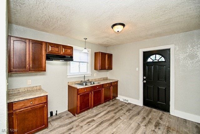 1628 Clark Ave SW, Canton, OH 44706 - kitchen featuring under cabinet range hood, a textured ceiling, light wood-type flooring, light countertops, and pendant lighting