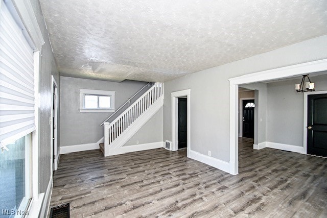 1628 Clark Ave SW, Canton, OH 44706 - unfurnished living room with wood finished floors, stairs, and a textured ceiling