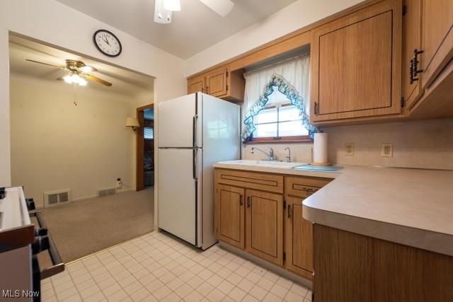 427 E 275th St, Euclid, OH 44132 - kitchen featuring a ceiling fan, freestanding refrigerator, light countertops, and brown cabinets