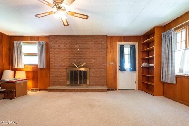 427 E 275th St, Euclid, OH 44132 - unfurnished living room with wooden walls, built in features, carpet flooring, a brick fireplace, and ceiling fan