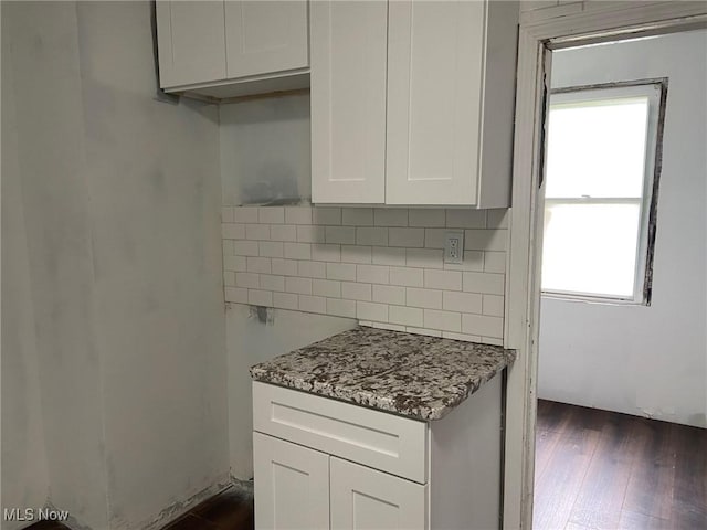 1122 W 17th St, Lorain, OH 44052 - kitchen with dark wood-style floors, backsplash, light stone counters, and white cabinetry