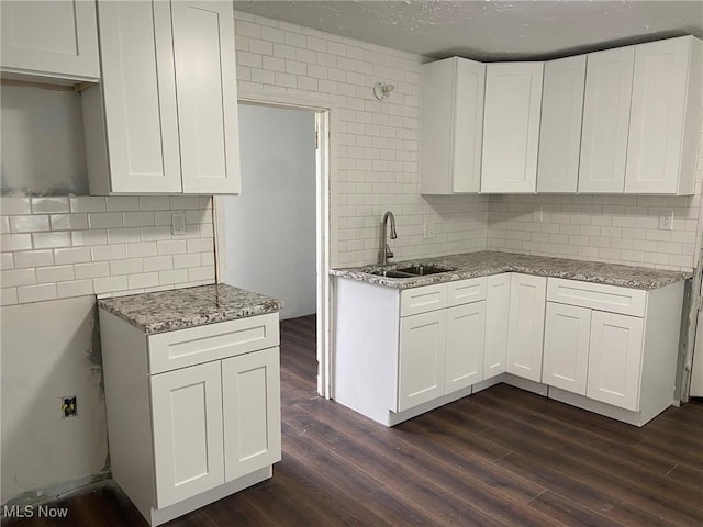 1122 W 17th St, Lorain, OH 44052 - kitchen featuring decorative backsplash, light stone countertops, dark wood-style flooring, and white cabinets