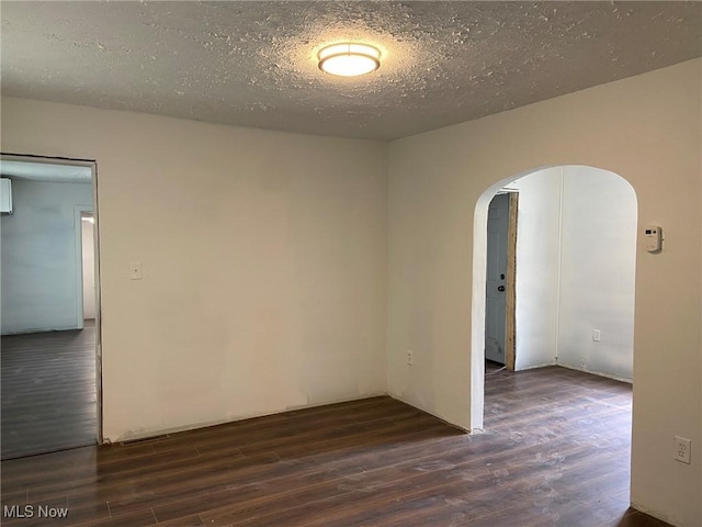 1122 W 17th St, Lorain, OH 44052 - empty room with wood finished floors, arched walkways, and a textured ceiling
