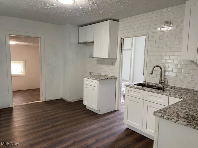 1122 W 17th St, Lorain, OH 44052 - kitchen featuring light stone counters, dark wood finished floors, a textured ceiling, and white cabinetry