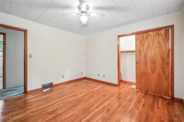 1808 Depot Rd, Salem, OH 44460 - unfurnished bedroom featuring light wood-type flooring, ornamental molding, a closet, ceiling fan, and a walk in closet