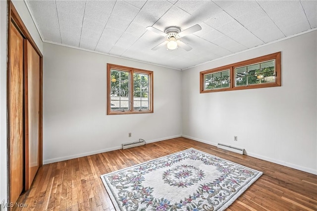1808 Depot Rd, Salem, OH 44460 - unfurnished bedroom featuring baseboard heating, wood-type flooring, a closet, crown molding, and ceiling fan