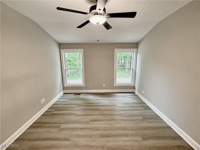 32054 Tuscan Ln Unit L-2, Avon Lake, OH 44012 - spare room featuring plenty of natural light, vaulted ceiling, a ceiling fan, wood finished floors, and a textured ceiling