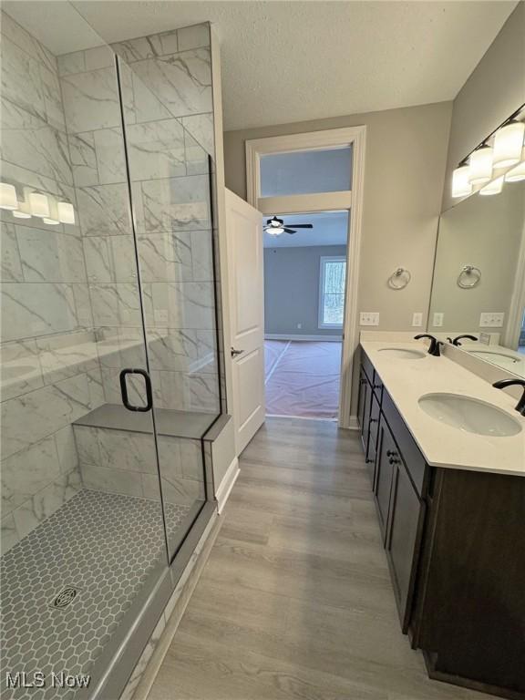 32054 Tuscan Ln Unit L-2, Avon Lake, OH 44012 - full bath with a marble finish shower, wood finished floors, double vanity, and a ceiling fan