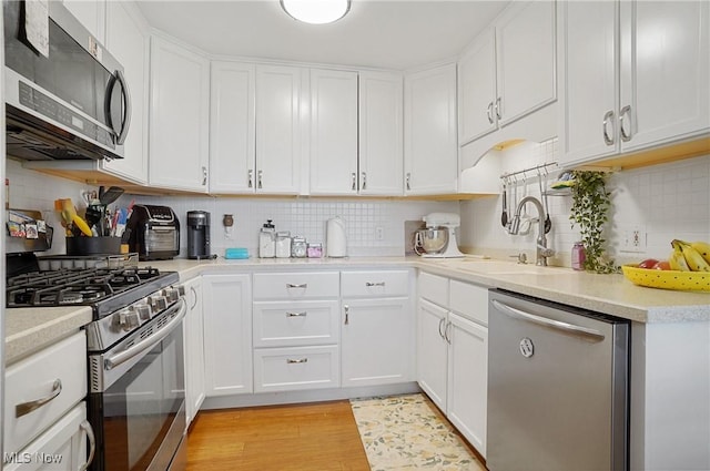 13 S River Rd, Munroe Falls, OH 44262 - kitchen featuring stainless steel appliances, decorative backsplash, light countertops, and light wood-type flooring