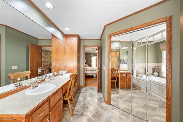 10400 Stoneacre St NW, Canal Fulton, OH 44614 - ensuite bathroom featuring crown molding, double vanity, a garden tub, marble look tiles, and recessed lighting