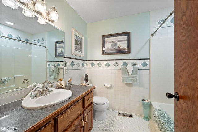 10400 Stoneacre St NW, Canal Fulton, OH 44614 - full bathroom with vanity, tile patterned floors, tile walls, tub / shower combination, and a wainscoted wall