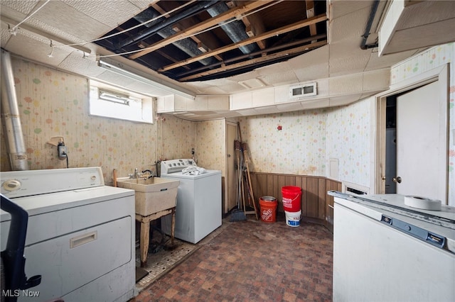 127 Brush Rd, Richmond Heights, OH 44143 - laundry area with wallpapered walls, washer and clothes dryer, wainscoting, and brick patterned floors