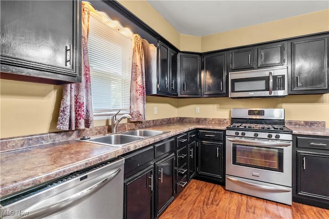 813 3rd St, Marietta, OH 45750 - kitchen with stainless steel appliances, dark cabinetry, and light wood-type flooring