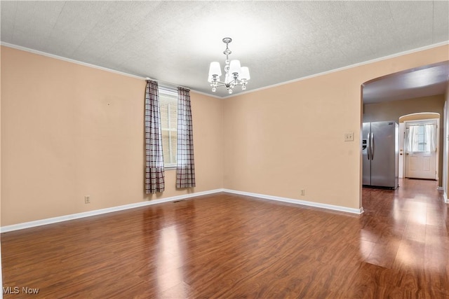813 3rd St, Marietta, OH 45750 - spare room featuring arched walkways, healthy amount of natural light, wood finished floors, ornamental molding, and a chandelier