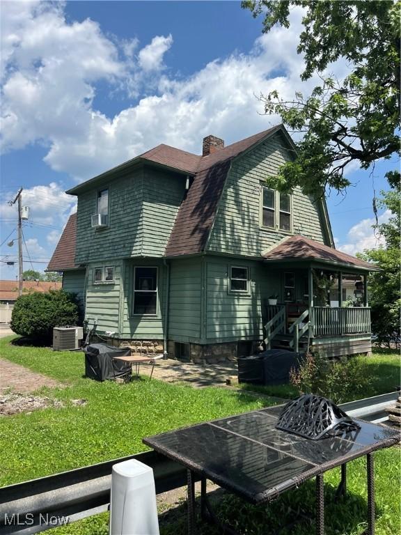 13 Neil St, Niles, OH 44446 - back of property featuring a gambrel roof, a porch, a lawn, a chimney, and a shingled roof