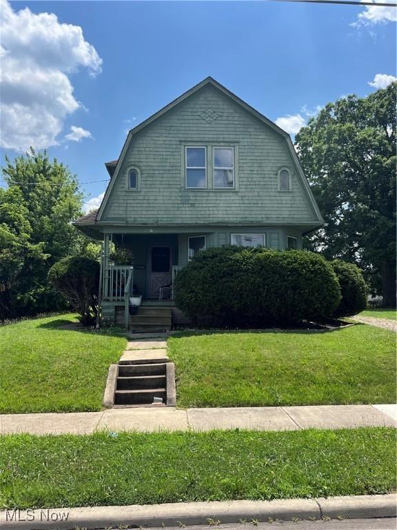 13 Neil St, Niles, OH 44446 - colonial inspired home with a gambrel roof, covered porch, and a front yard