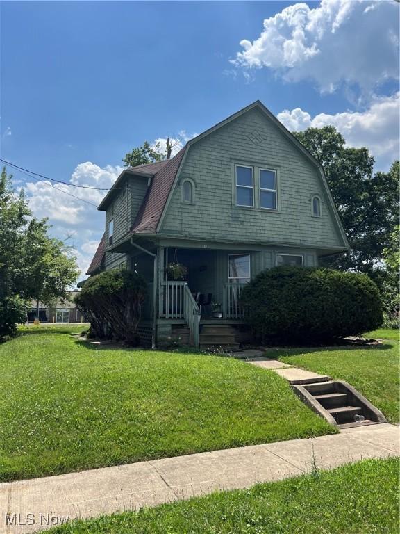 13 Neil St, Niles, OH 44446 - colonial inspired home with a gambrel roof, a porch, and a front lawn