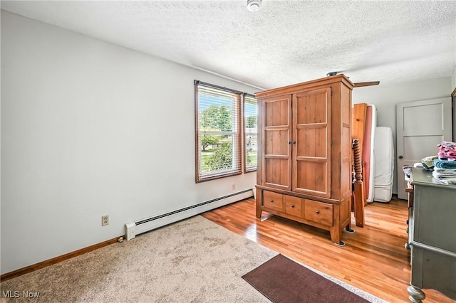 1683 Ridgewood Dr, Salem, OH 44460 - bedroom with a baseboard heating unit, a textured ceiling, and light wood-type flooring