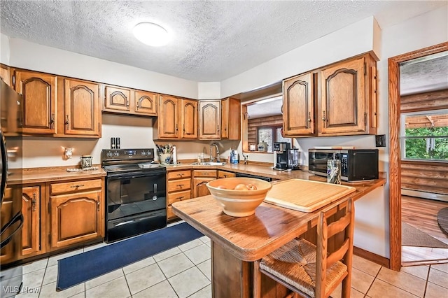 1683 Ridgewood Dr, Salem, OH 44460 - kitchen featuring black appliances, brown cabinetry, healthy amount of natural light, light countertops, and a textured ceiling