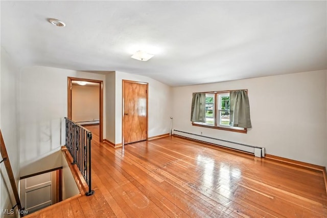 1683 Ridgewood Dr, Salem, OH 44460 - empty room with a baseboard heating unit, a baseboard radiator, wood-type flooring, and vaulted ceiling