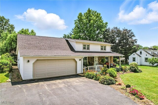 1683 Ridgewood Dr, Salem, OH 44460 - view of front of house featuring covered porch, asphalt driveway, a garage, and roof with shingles