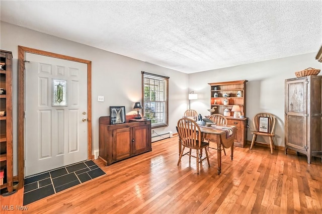 1683 Ridgewood Dr, Salem, OH 44460 - dining area with a baseboard heating unit, wood finished floors, and a textured ceiling