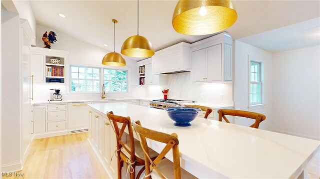 43 S St, Chagrin Falls, OH 44022 - kitchen featuring open shelves, dishwasher, a breakfast bar, a kitchen island, and white cabinetry