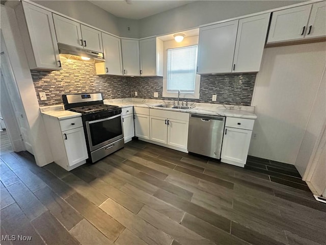 38 Franklin Ave, Niles, OH 44446 - kitchen with stainless steel appliances, under cabinet range hood, dark wood-style floors, white cabinetry, and backsplash