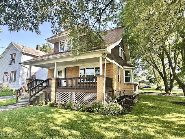 38 Franklin Ave, Niles, OH 44446 - view of front facade featuring brick siding, a front yard, and a porch