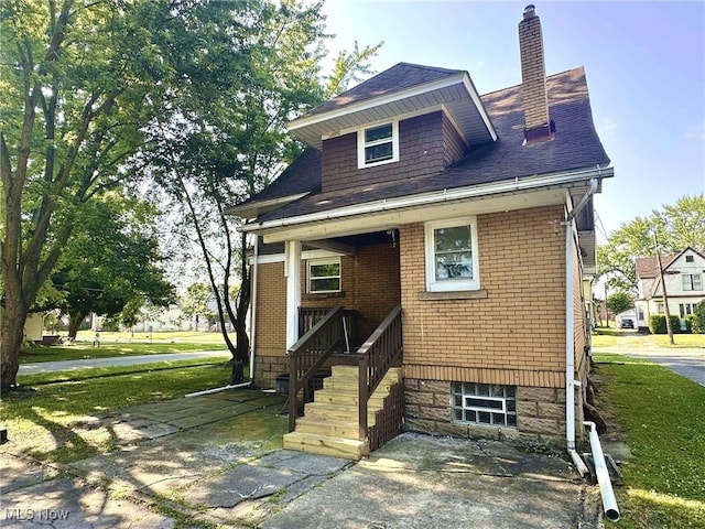 38 Franklin Ave, Niles, OH 44446 - view of front of home featuring a chimney, a shingled roof, brick siding, and a front yard