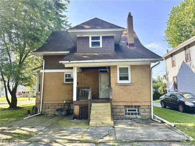 38 Franklin Ave, Niles, OH 44446 - rear view of house with covered porch, a chimney, a lawn, roof with shingles, and brick siding