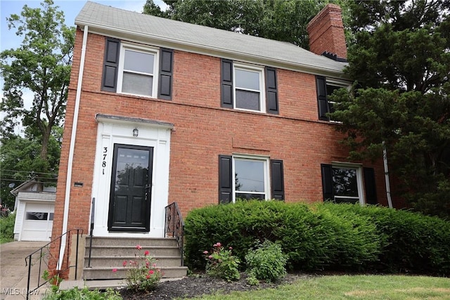 3781 Washington Blvd, University Heights, OH 44118 - view of front of home featuring brick siding, an outdoor structure, a chimney, and a garage